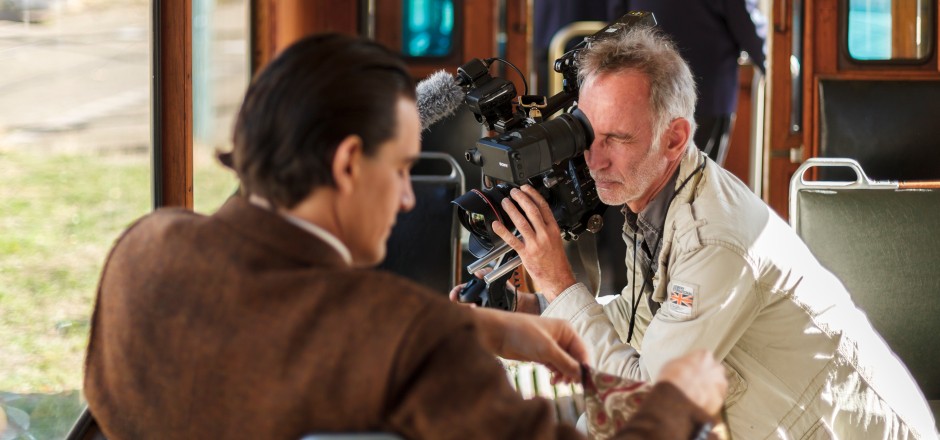Dreh in historischer Straßenbahn. Kameramann filmt mit Kamera auf seiner Schulter den sitzenden Schauspieler Jonathan Schimmer.