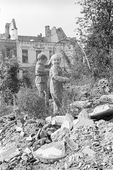 Zwei Kinder spielen in einem Steinhaufen