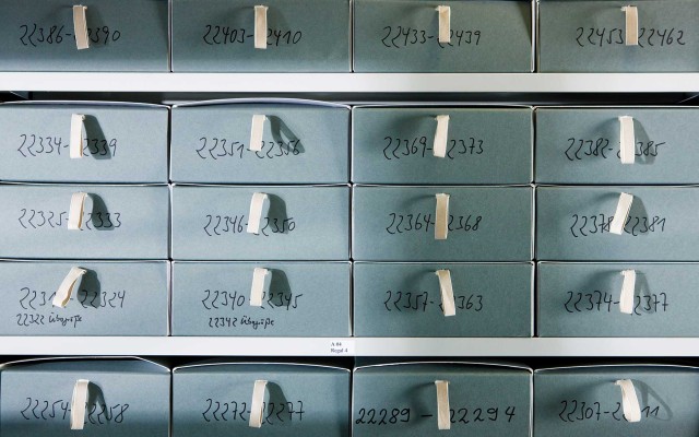 Graue Kartons  mit Nummern beschriftet und mit einer Stofflasche zum Öffnen