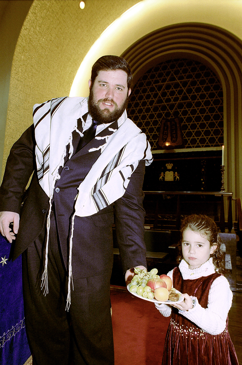 Ein Mann mit einem Kind, das einen Teller mit Früchten trägt