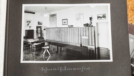 Schwarz-weiss-Foto eines Archivraumes mit einem Regal mit vielen schmalen Fächern für Filmdosen