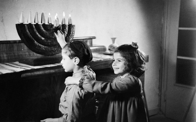 Zwei Kinder zünden Kerzen an