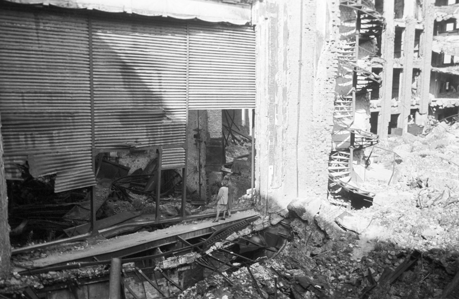 Eine Frau steht vor einem beschädigten Gebäude
