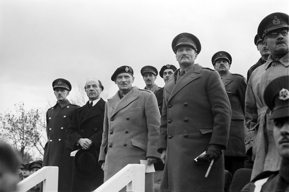 Männer in Uniform stehen auf einer Tribüne