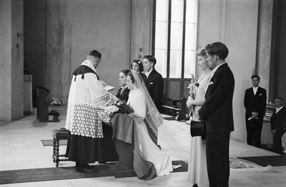 Ein Brautpaar kniet vor einem Geistlichen