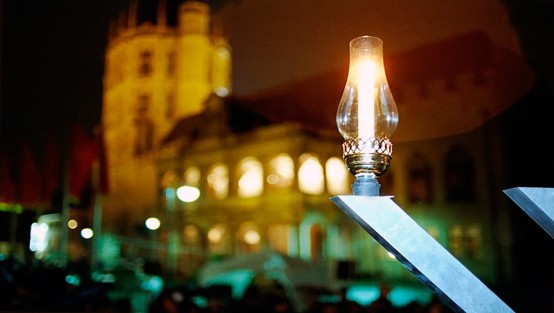 Eine Kerze mit dem Rathaus von Köln im Hintergrund