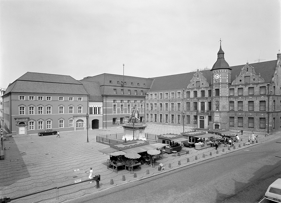 Ein Platz mit Marktständen und mehreren Gebäuden.