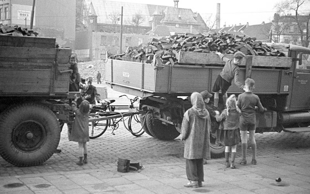 Kinder stehlen in der Altstadt von Düsseldorf Briketts vom Kohlenwagen.
