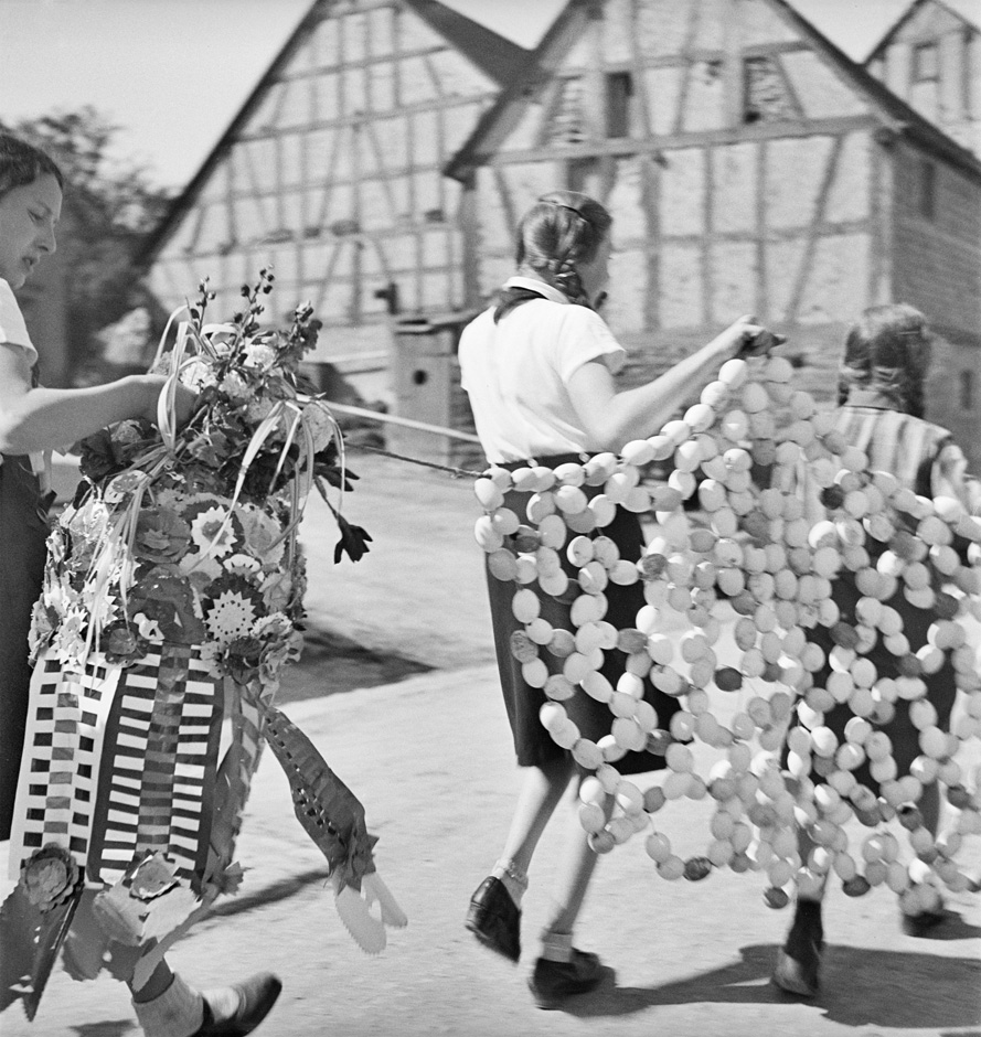 Mädchen tragen eine Pfingstkrone.