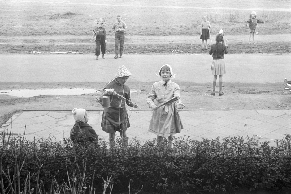Kostümierte Kinder stehen an einer Straße.