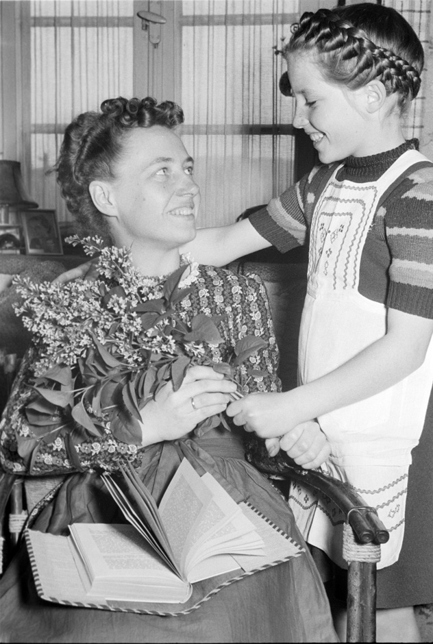 Ein Mädchen steht neben einer Frau.