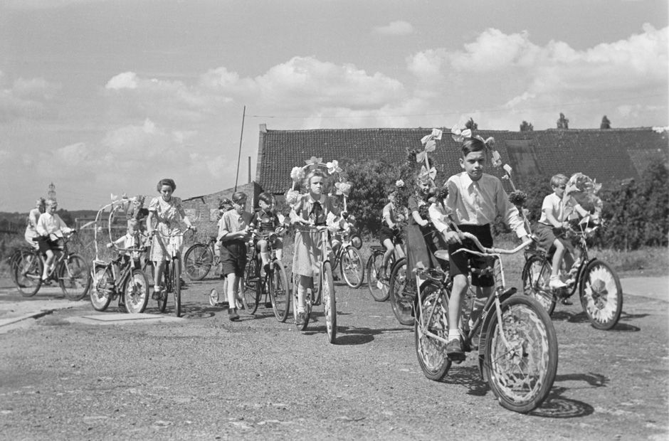 Kinder fahren auf Fahrrädern, die geschmückt sind.