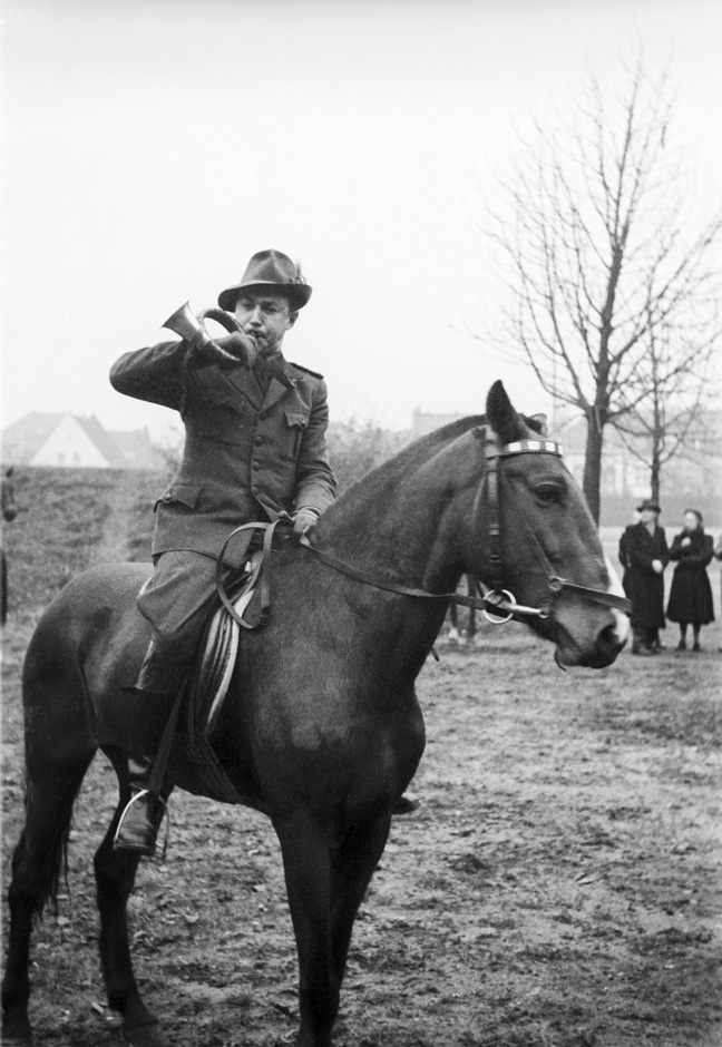 LVR-ZMB, C.A. Stachelscheid Ein Mann sitzt auf einem Pferd und bläst in ein Horn.