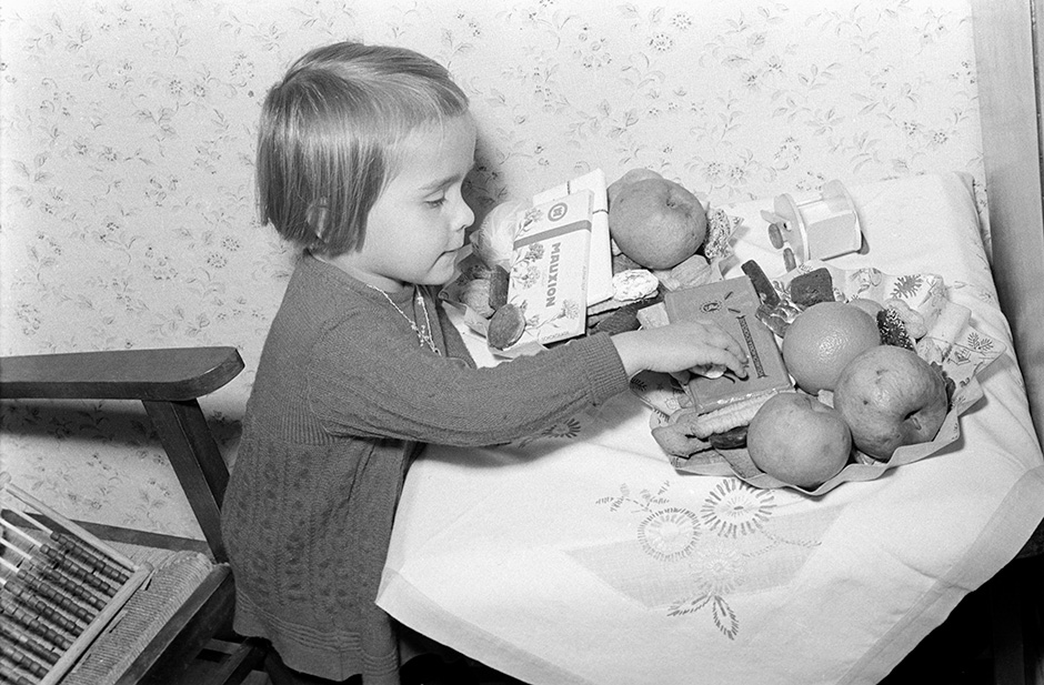 Ein Mädchen mit einem Teller mit Süßigkeiten.