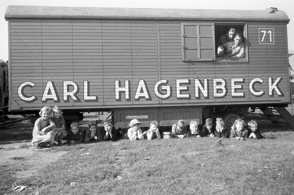 LVR-ZMB, C.A. Stachelscheid Kinder liegen unter einem Zirkuswagen.
