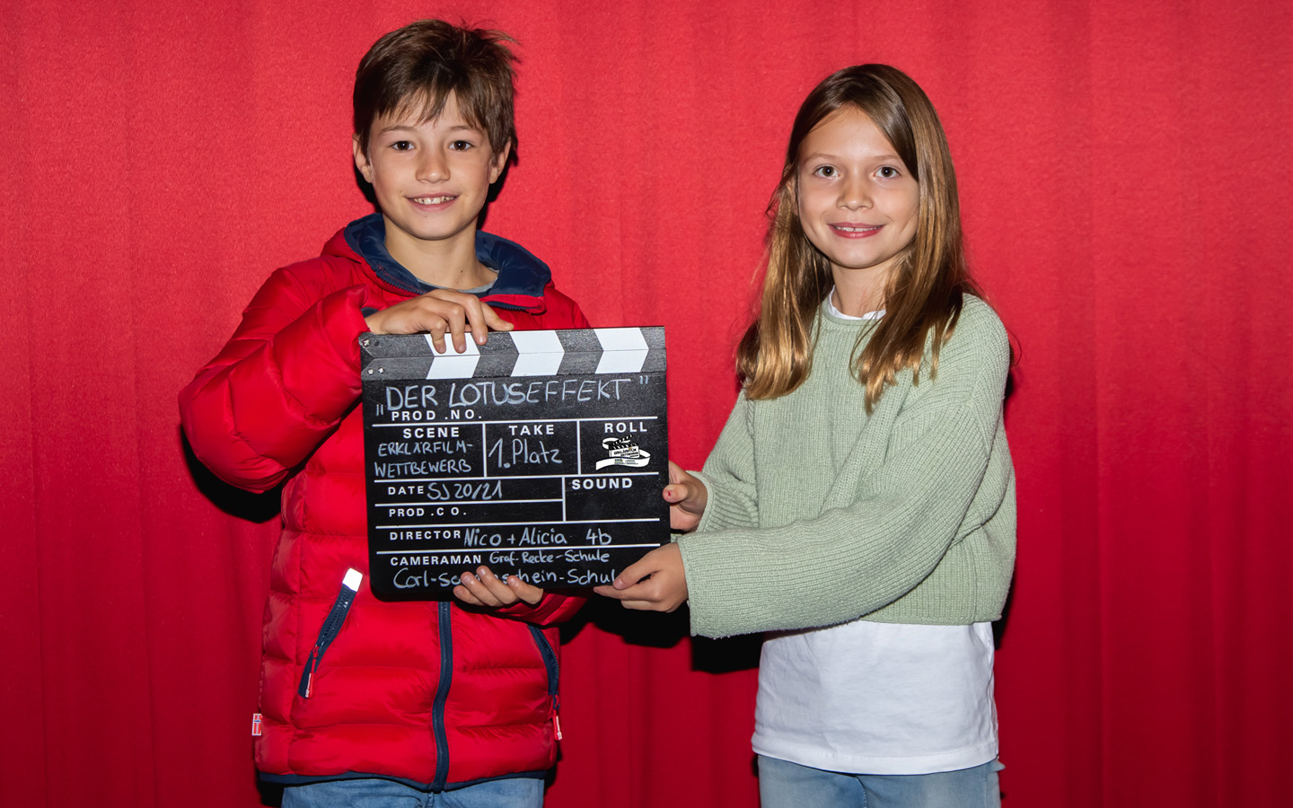 Gewinner vor Roter Leinwand mit Filmklappe