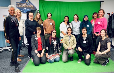 Die Fachkräfte und das Netzwerk "MEDITA" versammelt auf einem Gruppenfoto vor einem Greenscreen.