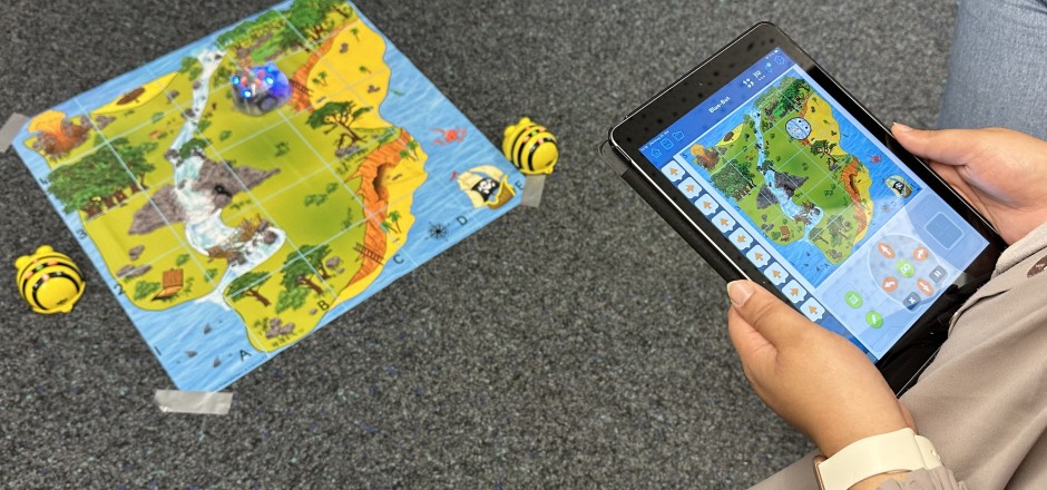 Lehrende am iPad mit Bildungsroboter Bee-Bot