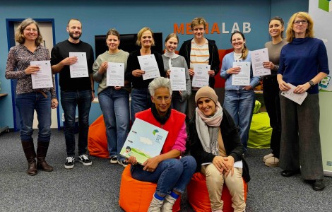 Viele Teilnehmende posieren mit Urkunden für ein Foto.