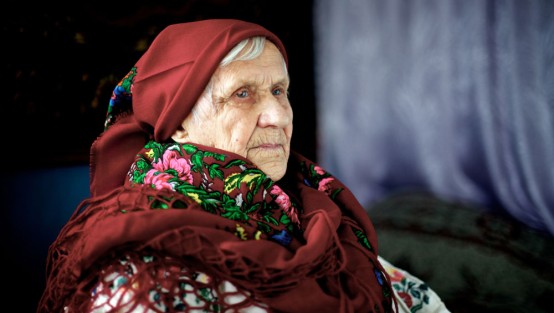 Bild einer alten Frau mit rotem Tuch um Kopf und Hals
