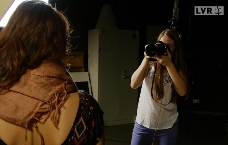 Eine junge Fotografin fotografiert eine junge Frau.