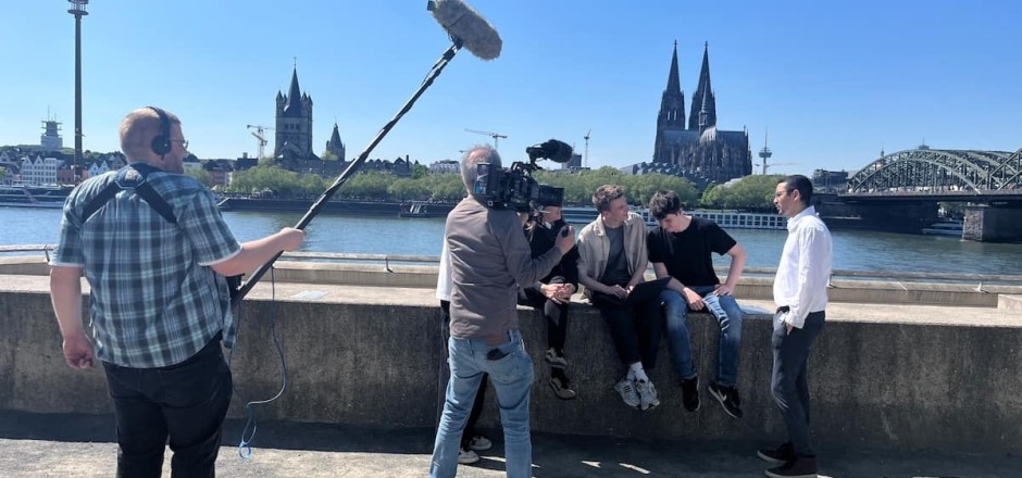 Kamerateam filmt Jugendliche am Kölner Rheinufer.