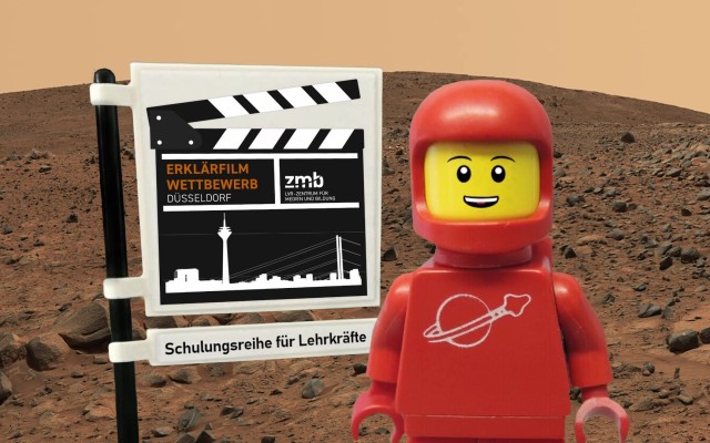 Auf dem Mars: Eine Legofigur im roten Raumanzug steht neben einer Flagge, auf dem das Logo des Erklärfilmwettbewerbs abgebildet ist. Darunter steht "Schulungsreihe für Lehrkräfte"