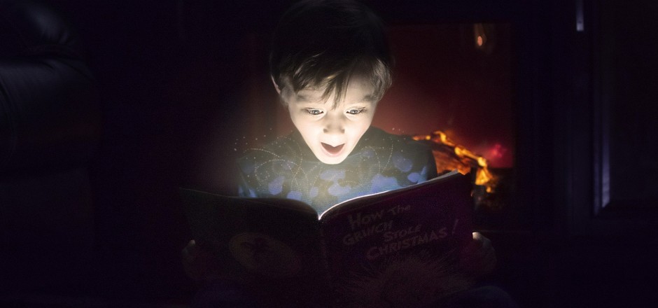 Junge blickt in iluminiertes Buch